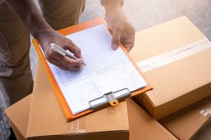 Warehouse Worker Writing On Paper Clipboard Checking Stock Inventory Management Of Product 1